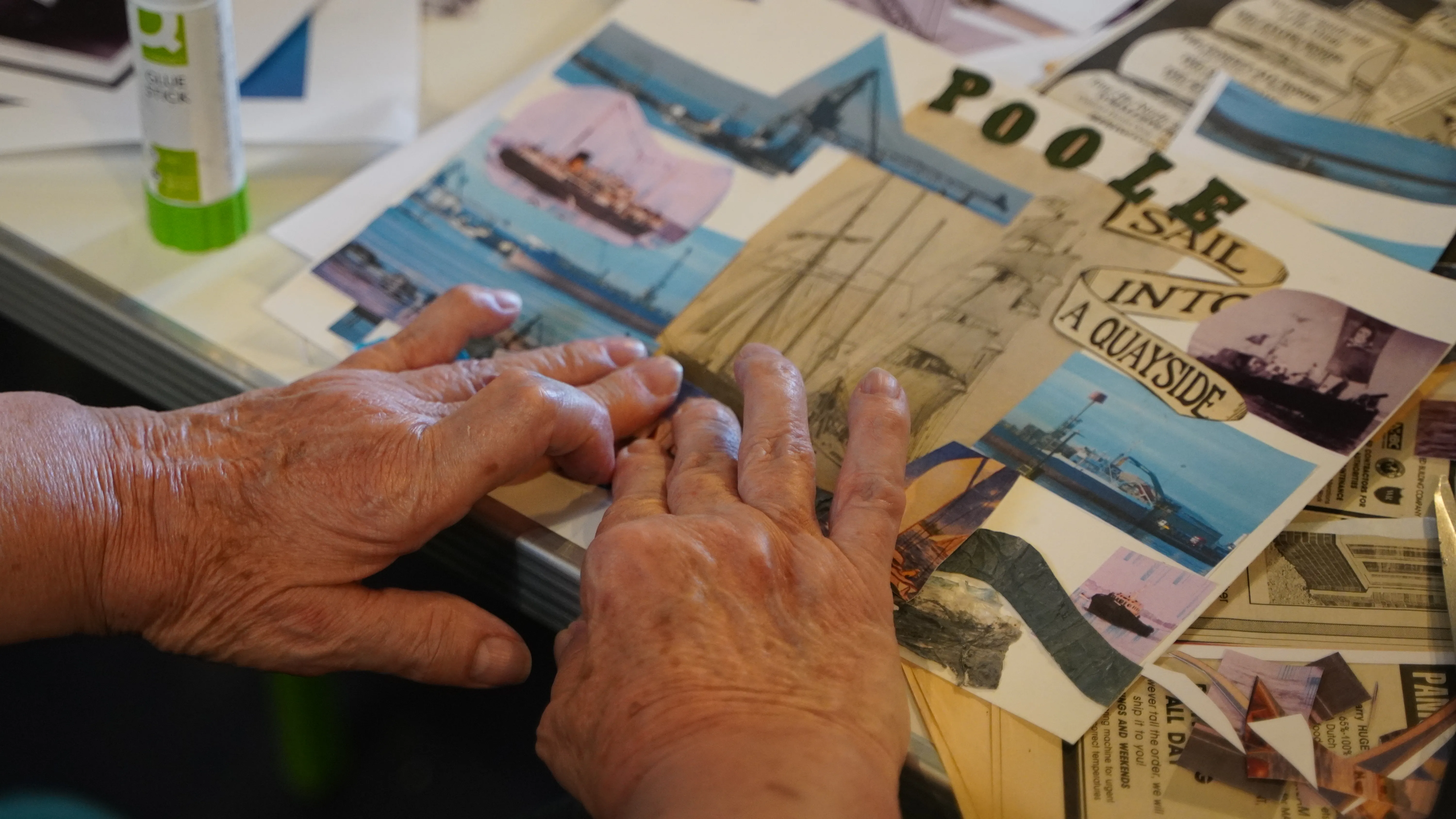 Two elderly hands arrange photos on a collage. They include historic photos of beating the bounds, and sunseeker boats on Poole Quay.